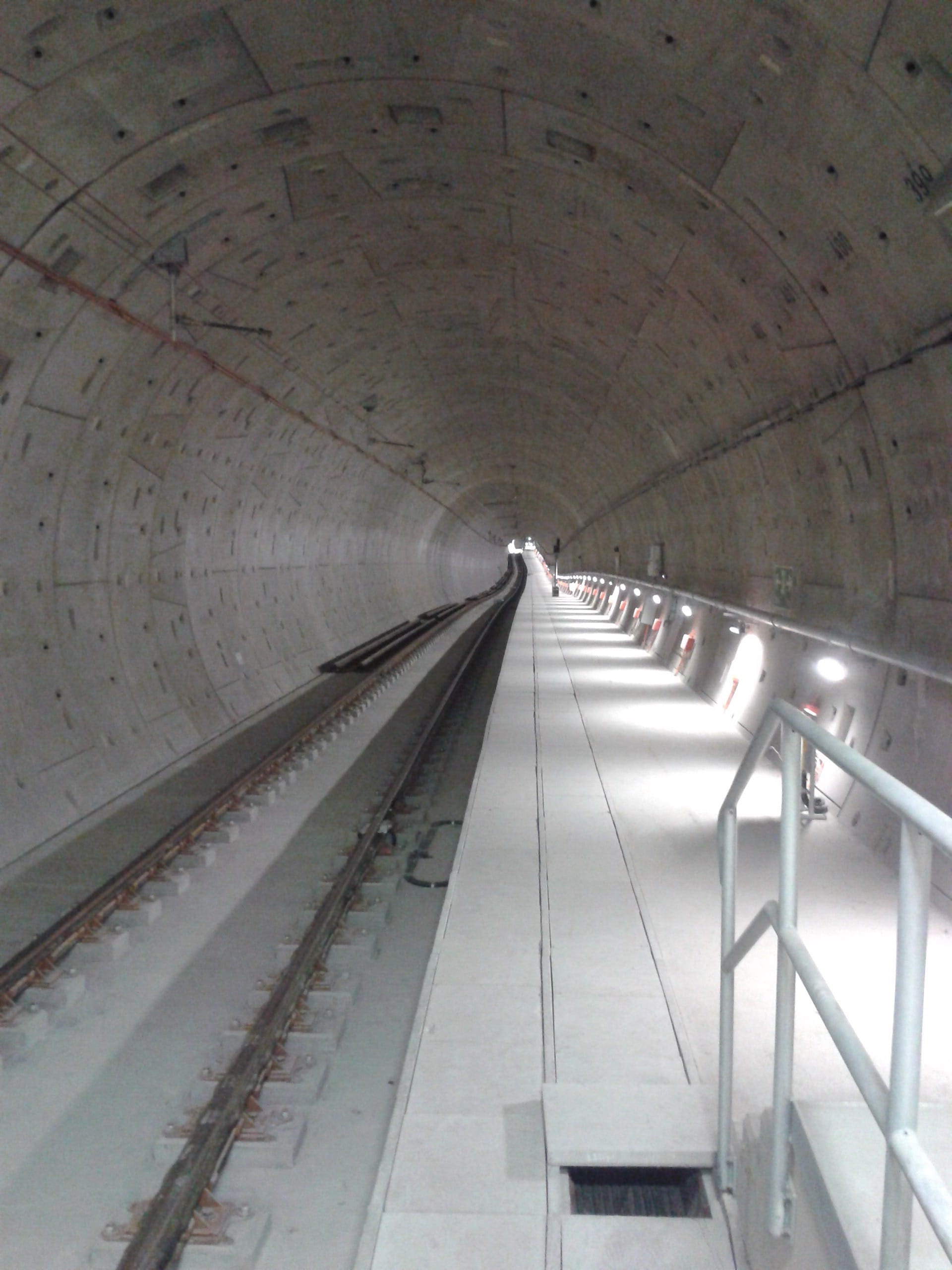 Baustelle U-Bahn Röhre innen, Schienen verlaufen in Flucht im Rohbau im kreisrunden Tunnel